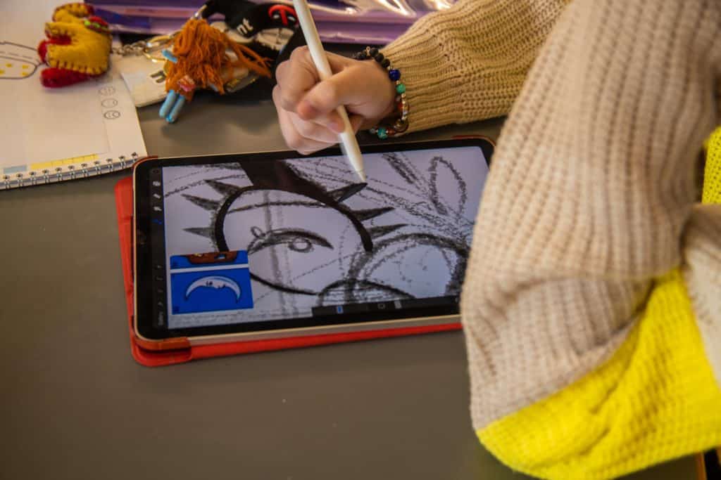 Close up photograph of an artist drawing on an iPad