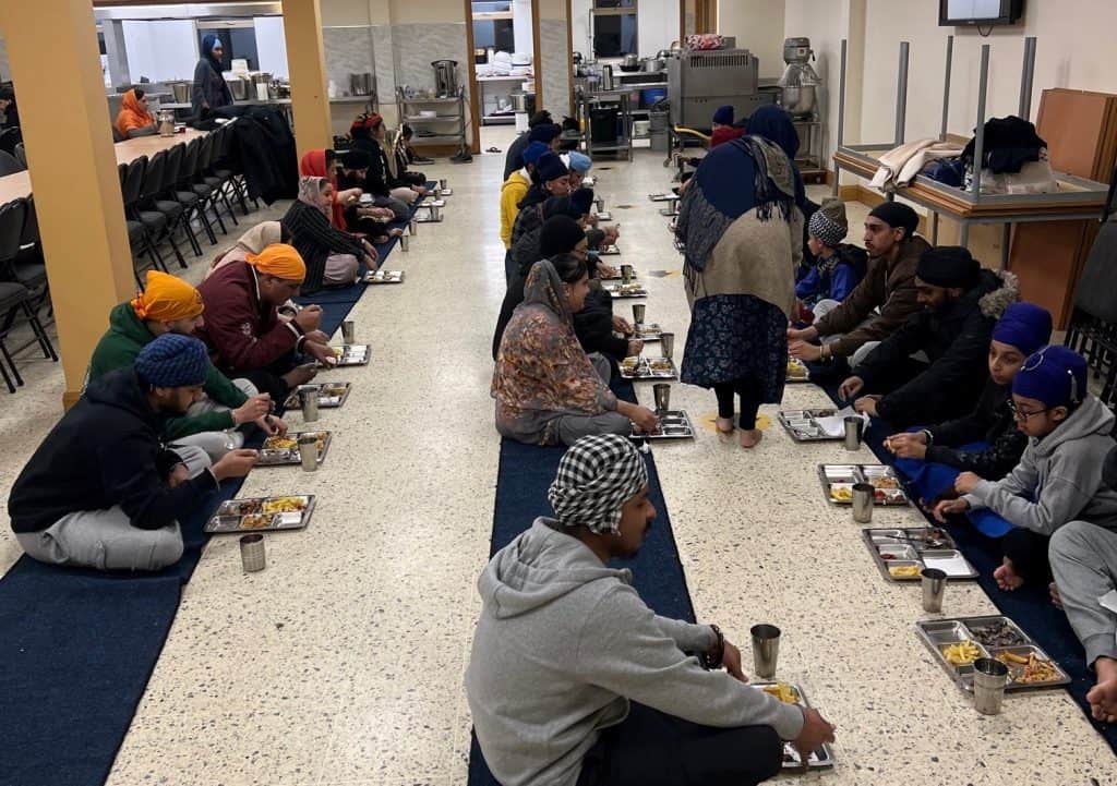 Photograph of Sikh group having a meal during Viasaki celebrations