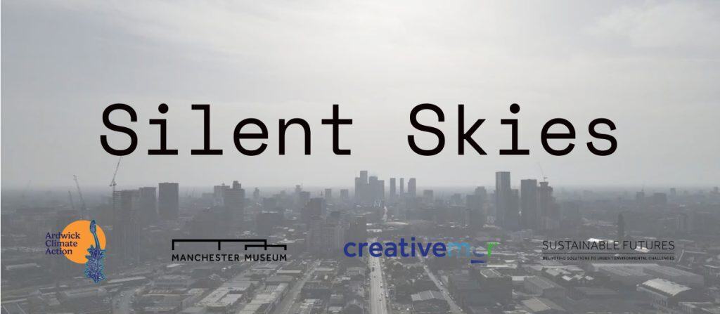 A view across a hazy Manchester cityscape with the words Silent Skies